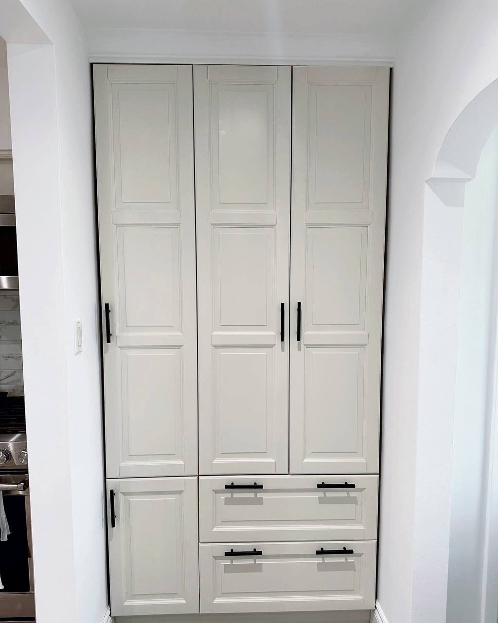 After photo of the same kitchen with newly painted off-white (Mist Air by Benjamin Moore) cabinets and pantry doors, featuring new gold hardware and a brighter, more open feel ~ George town, Toronto.