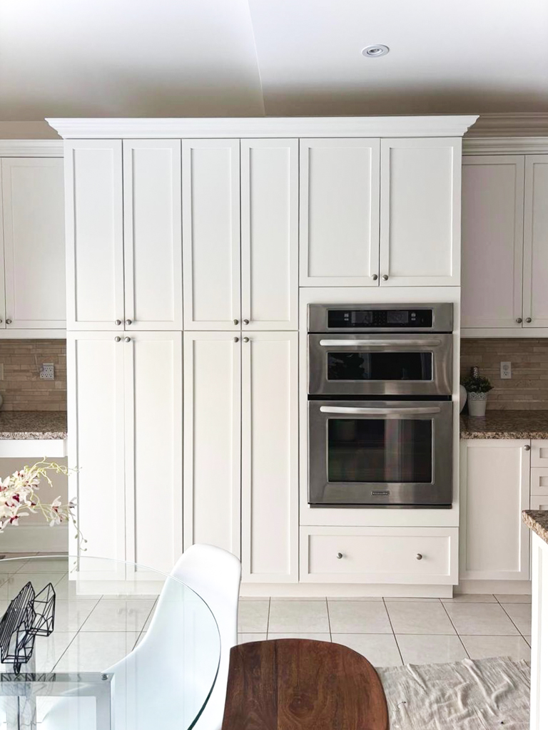 Kitchen cabinets professionally refinished by the best cabinet painter toronto to a durable, warm white with a flawless factory-like finish.