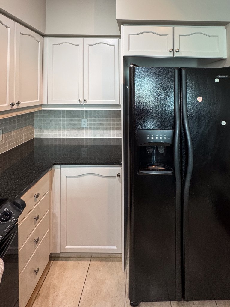 Refinished kitchen cabinet doors in a Toronto condo, painted a soft off-white with a hint of gray (Benjamin Moore's Pale Oak). The finish is smooth, modern, and bright.