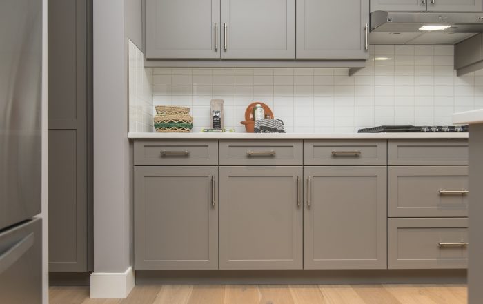Modern kitchen with professionally refinished grey cabinets, new hardware, and a bright countertop in a home in Richmond Hill, Toronto.