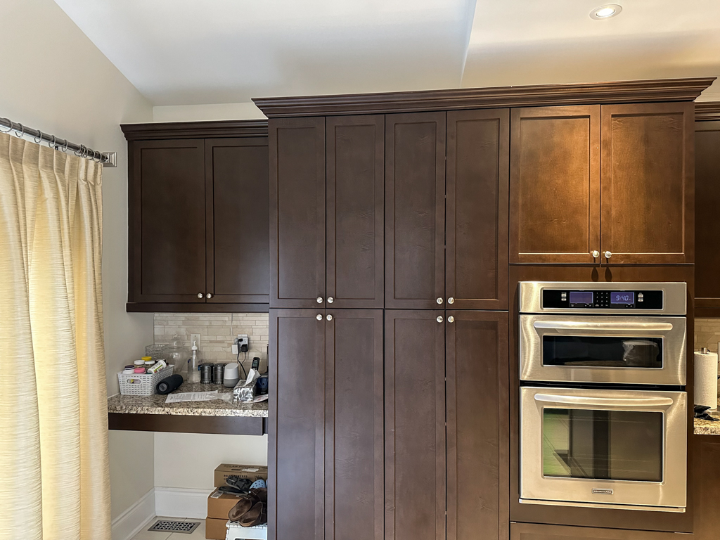 Before photo of dark brown stained cabinets with visible surface wear and fading, showing the need for professional refinishing.